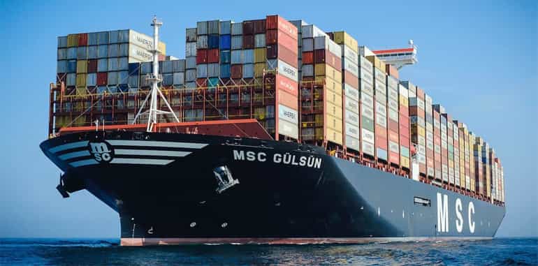 freight vessel stacked high with shipping containers